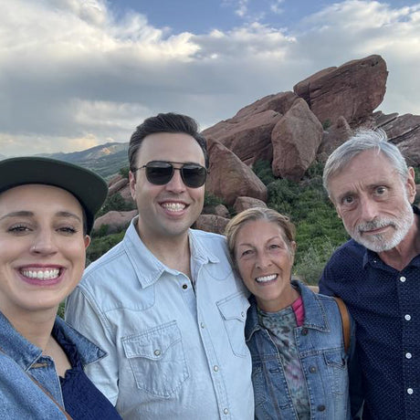 Four people posing for a selfie with red rock formations in the background