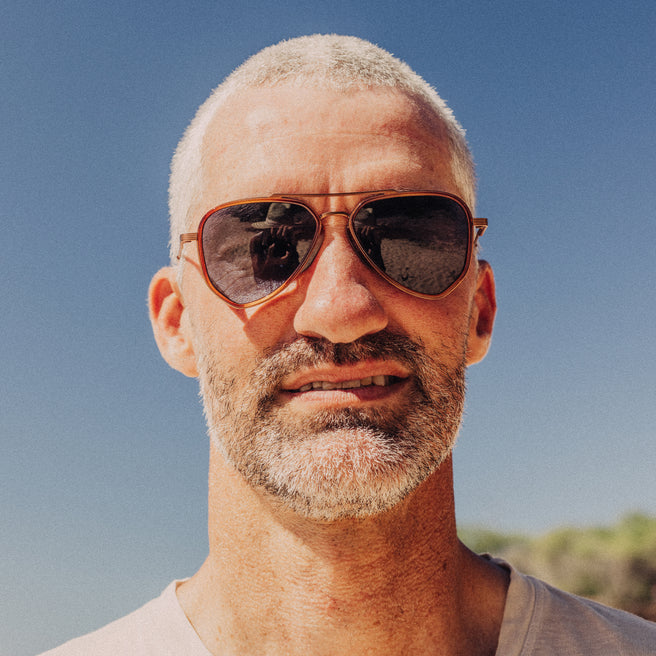 Man wearing sunglasses with a clear blue sky background