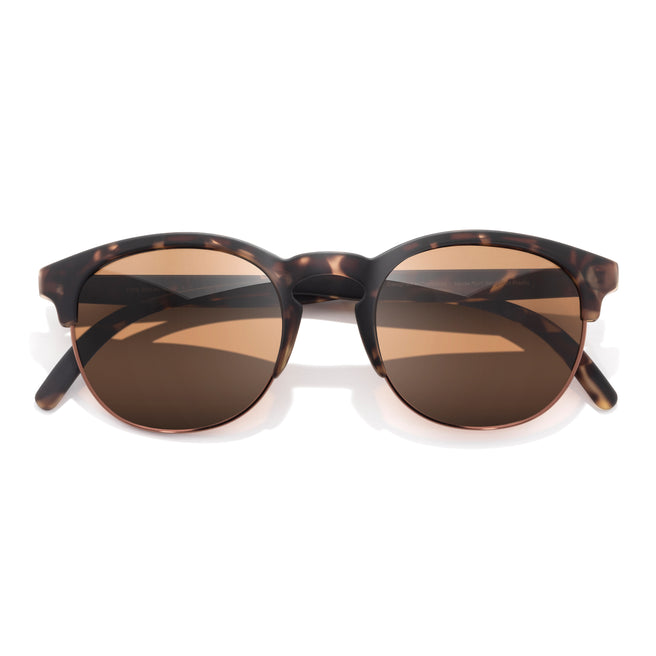 Sunglasses with tortoiseshell frame and brown lenses on a white background