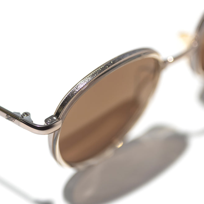 Close-up of a pair of sunglasses with a reflective surface on a white background