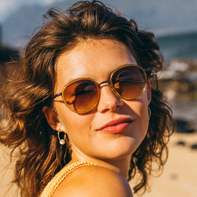 Woman wearing sunglasses with a blurred natural background