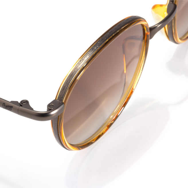 Sunglasses with brown lenses and gold frames on a white background