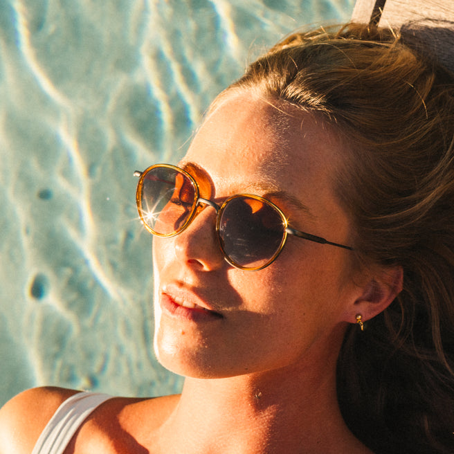 Woman wearing sunglasses by a pool