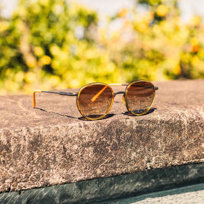 Sunglasses on a stone surface with a blurred natural background