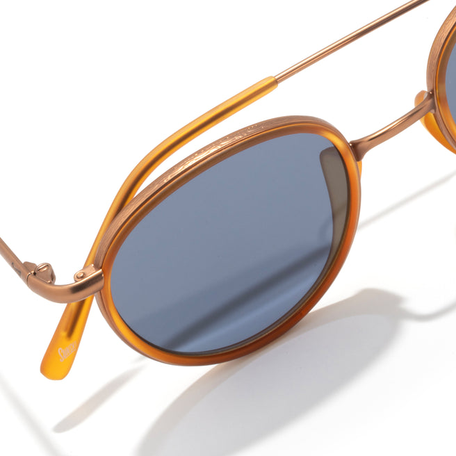 Sunglasses with gold frame and blue lenses on a white background