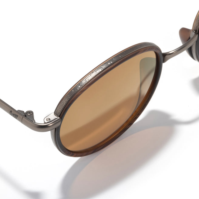 Brown sunglasses with a reflective lens on a white background