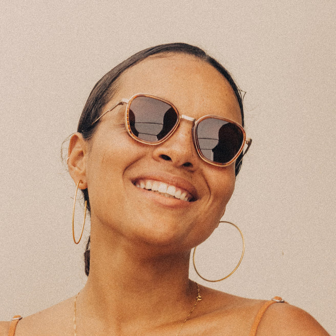 Woman wearing sunglasses with a neutral background