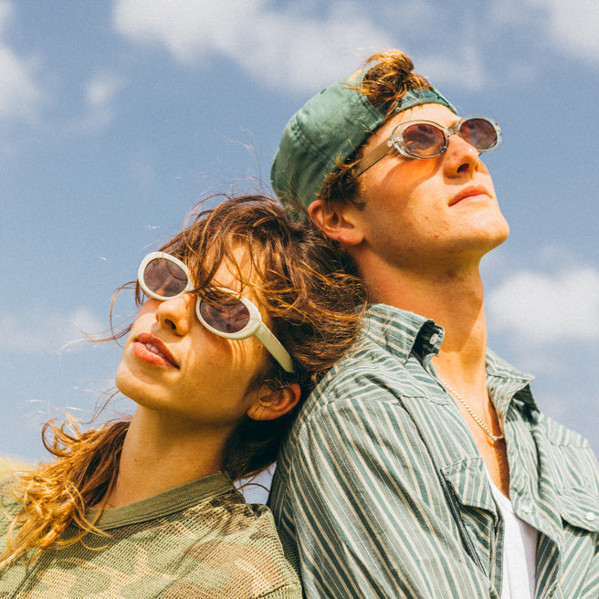 Two people wearing sunglasses against a blue sky