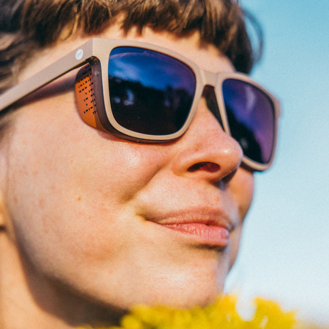 Close-up of a person wearing sunglasses with a blurred background