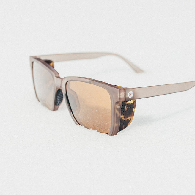 Sunglasses with a tortoiseshell frame and brown lenses on a white background