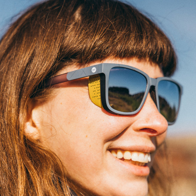 Person wearing sunglasses with a blurred natural background