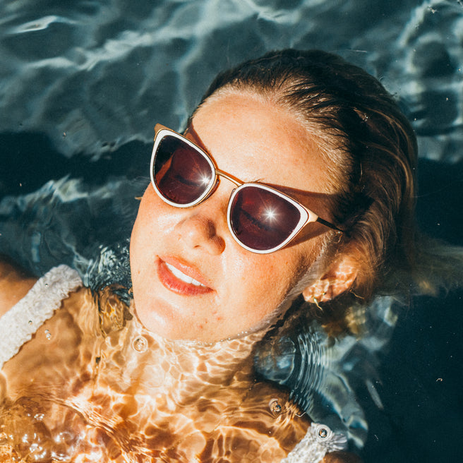 Person wearing sunglasses floating in water