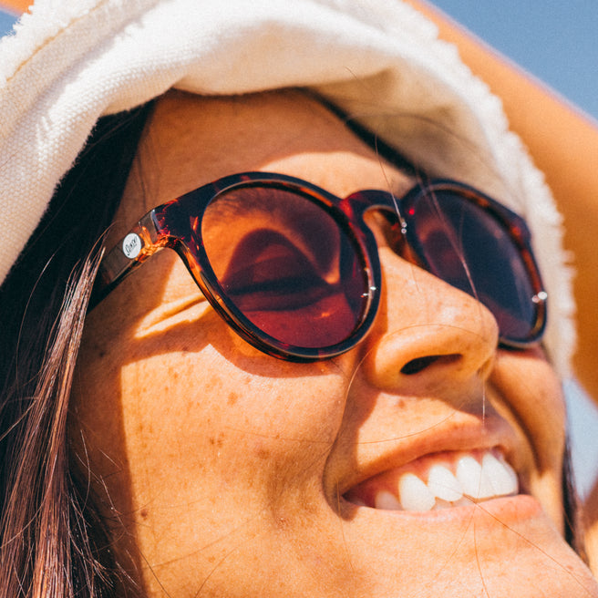 Person wearing sunglasses and a bucket hat outdoors