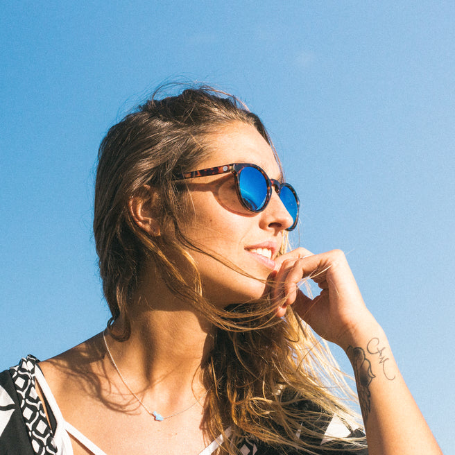 Woman wearing sunglasses with a clear blue sky background