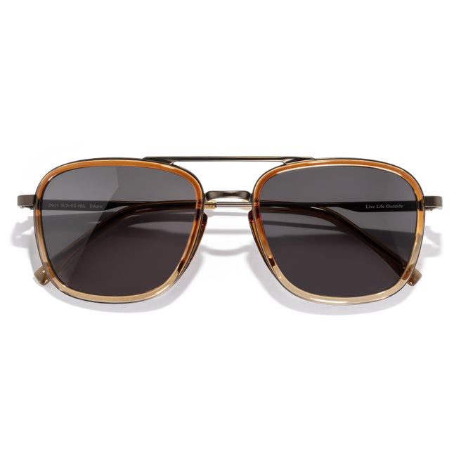 Sunglasses with gold frame and dark lenses on a white background