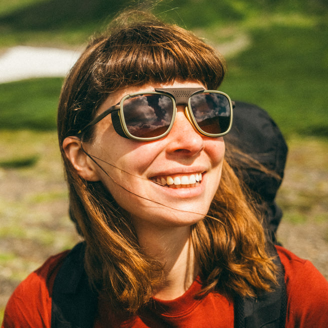 Person wearing large sunglasses with a blurred natural background