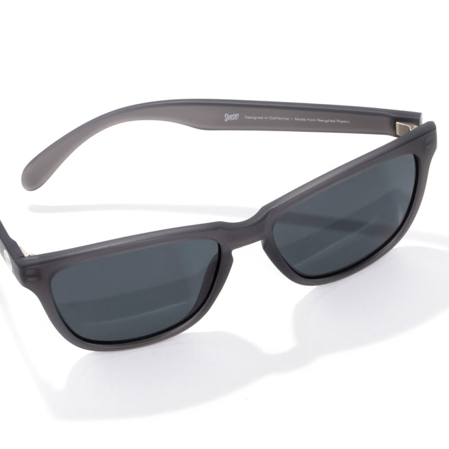 Sunglasses with dark lenses and gray frame on a white background
