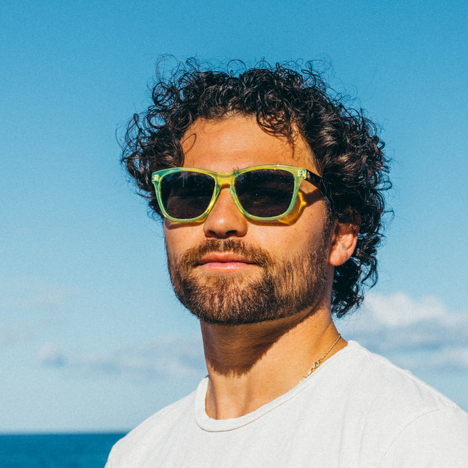 Man wearing sunglasses with a clear blue sky and ocean in the background