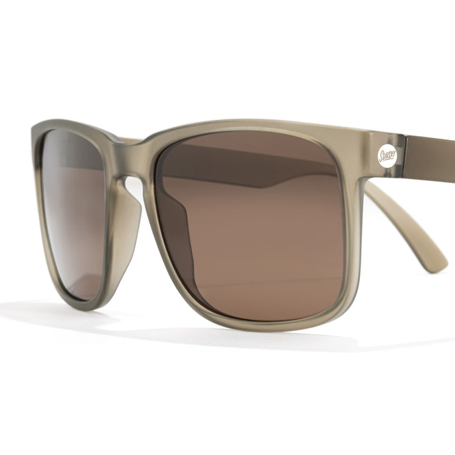 Sunglasses with brown lenses and beige frame on a white background
