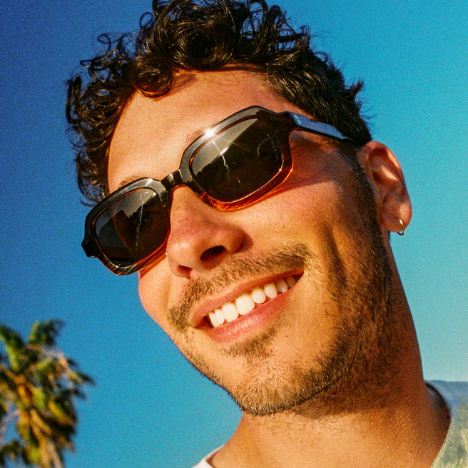 Man wearing sunglasses with a clear blue sky background