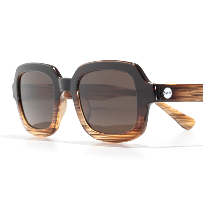 Sunglasses with striped frame and dark lenses on a white background