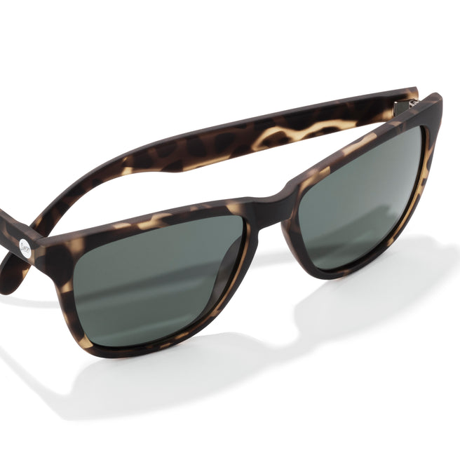 Sunglasses with tortoiseshell frame and dark lenses on a white background