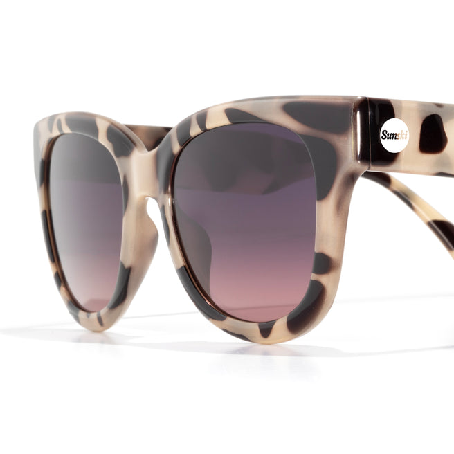 Sunglasses with tortoiseshell frame and gradient lenses on a white background