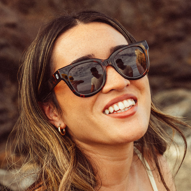 Woman wearing sunglasses with a blurred natural background