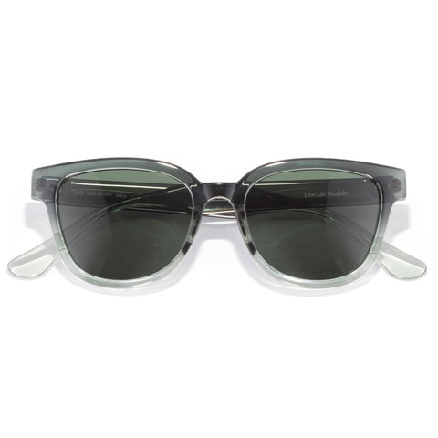 Miho - Pine Fade Forest - Sunglasses with clear frame and dark lenses on a white background