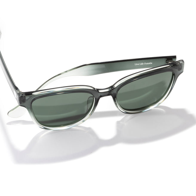 Sunglasses with a clear frame and dark lenses on a white background