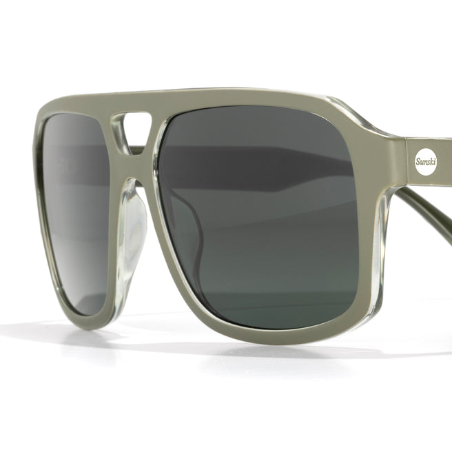 Sunglasses with a green frame and dark lenses on a white background