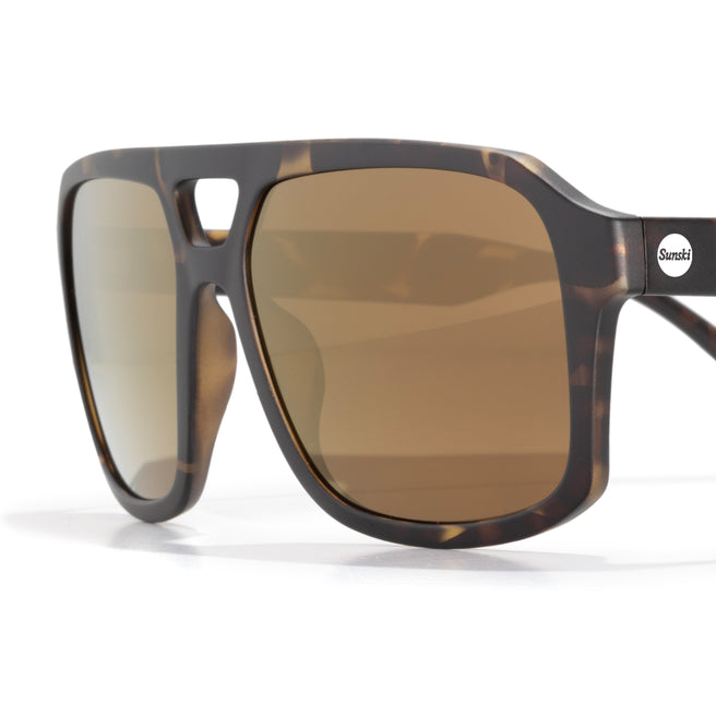 Sunglasses with tortoiseshell frame and brown lenses on a white background