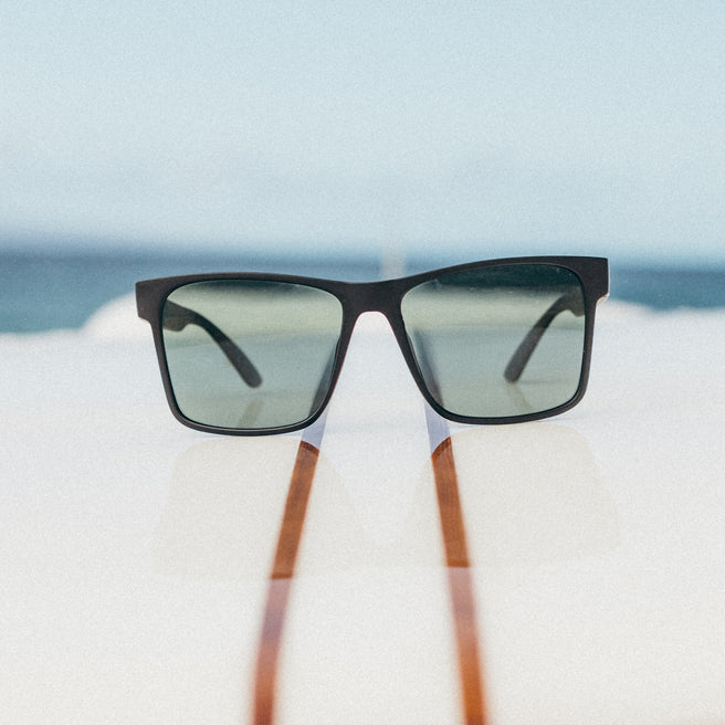 Sunglasses with wooden arms on a blurred beach background