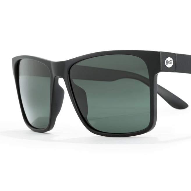 Black sunglasses with green lenses on a white background