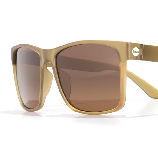 Gold-framed sunglasses with brown lenses on a white background