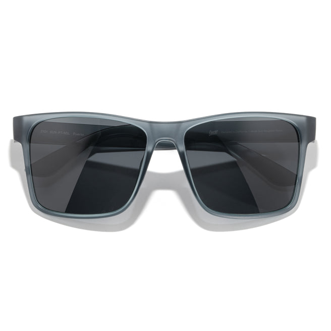 Sunglasses with gray frame and dark lenses on a white background