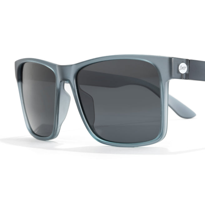 Sunglasses with gray frame and dark lenses on a white background