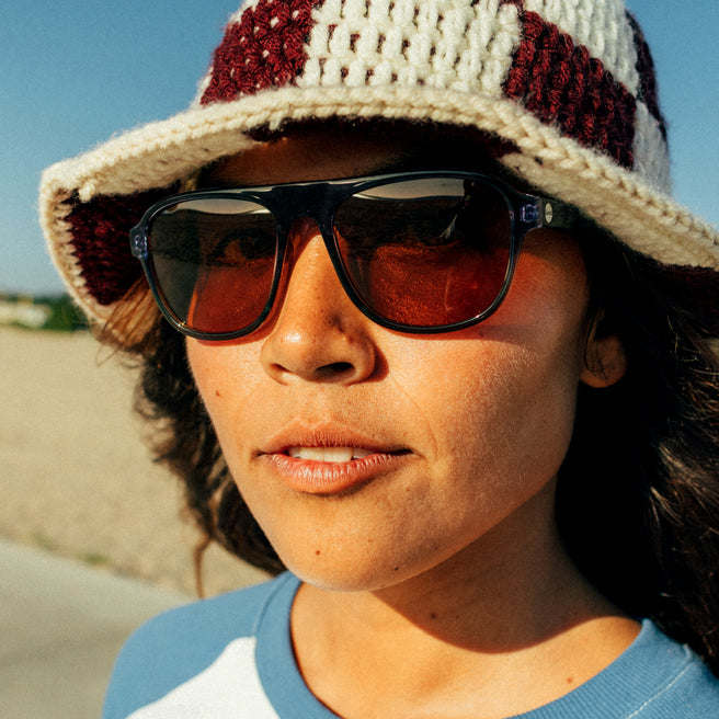 Person wearing a checkered hat and sunglasses outdoors