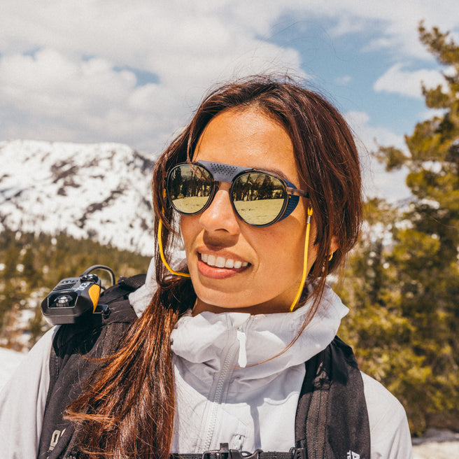 Woman wearing sunglasses with a mountainous landscape in the background