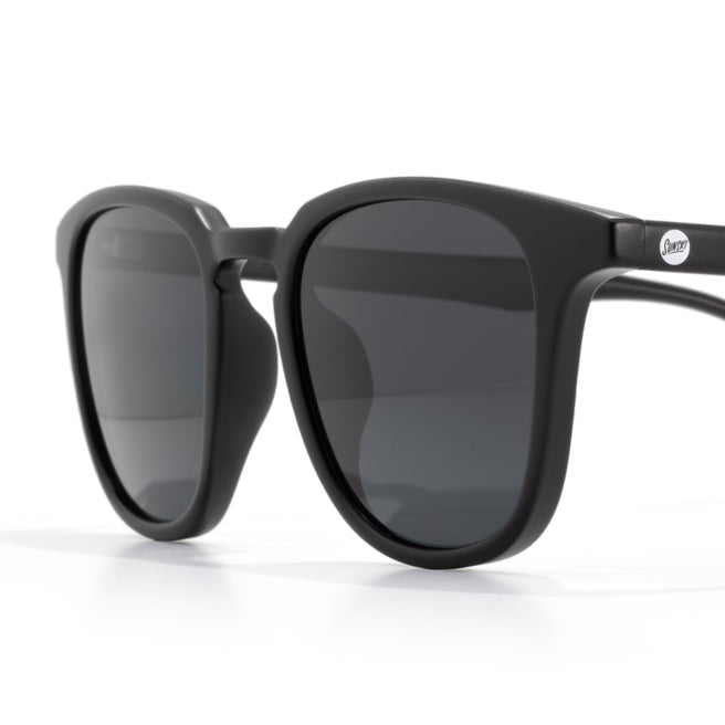 Black sunglasses with dark lenses on a white background