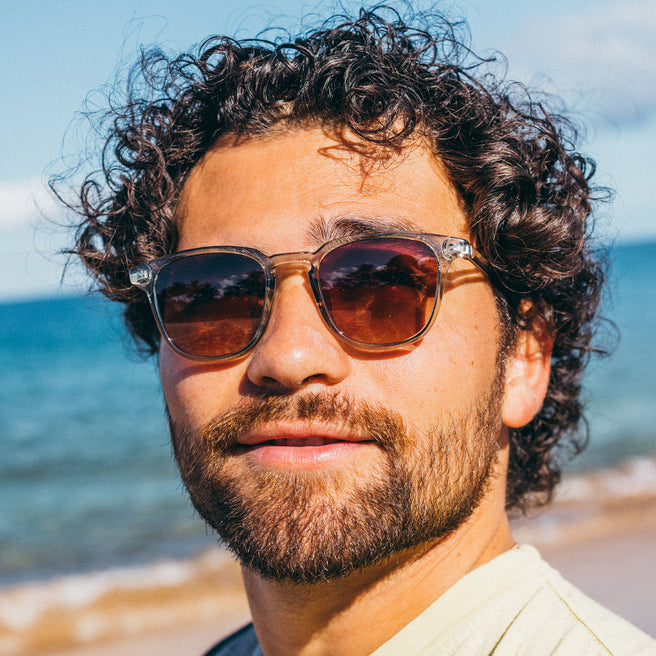 Man wearing sunglasses with a beach background