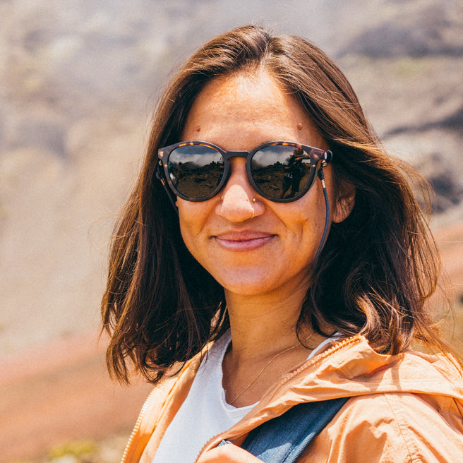 Woman wearing sunglasses with a mountainous landscape in the background