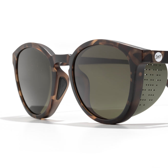 Sunglasses with tortoiseshell frame and dark lenses on a white background