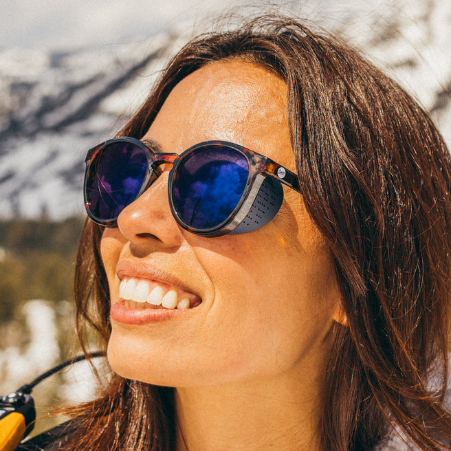 Woman wearing sunglasses with a mountainous background