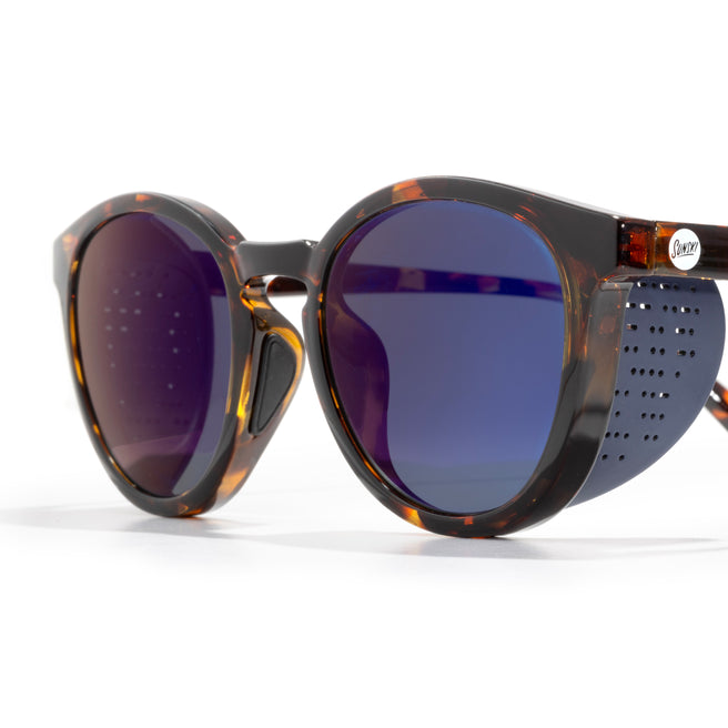 Sunglasses with tortoiseshell frame and blue lenses on a white background