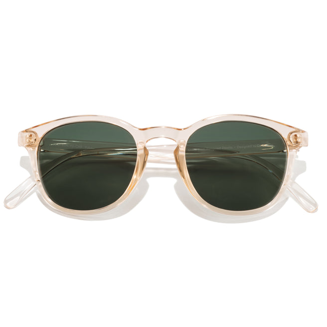 Sunglasses with gold frame and green lenses on a white background