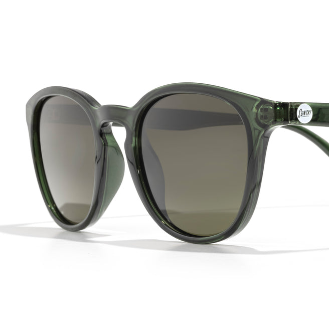 Green sunglasses with dark lenses on a white background