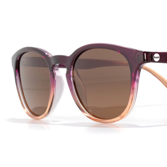 Sunglasses with a purple and rose gold frame on a white background