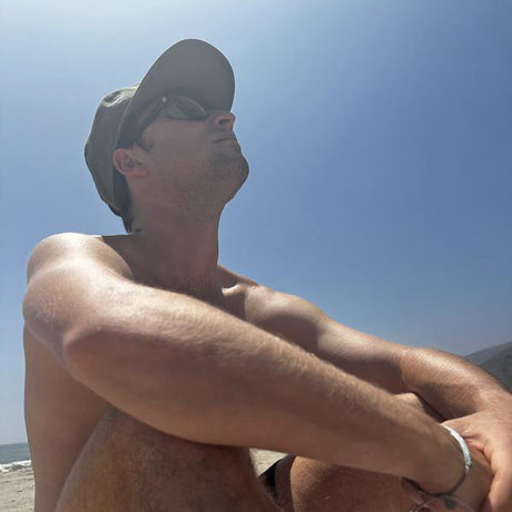 Man sitting on a beach with a clear blue sky