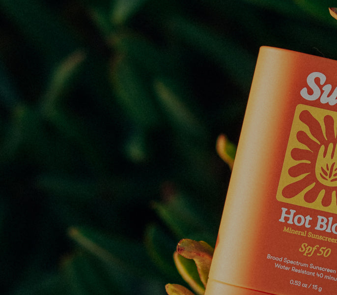 Sunscreen bottle with SPF 50 label on a blurred green background